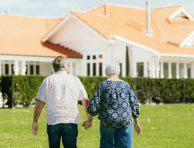 A-Karaka-Pines-village-couple-walking-hand-in-hand-to-the-clubhouse-reflecting-a-calm-setting